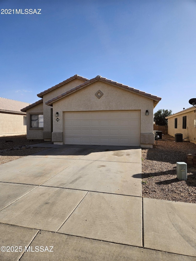 view of front of home featuring a garage, a tile roof, driveway, and stucco siding