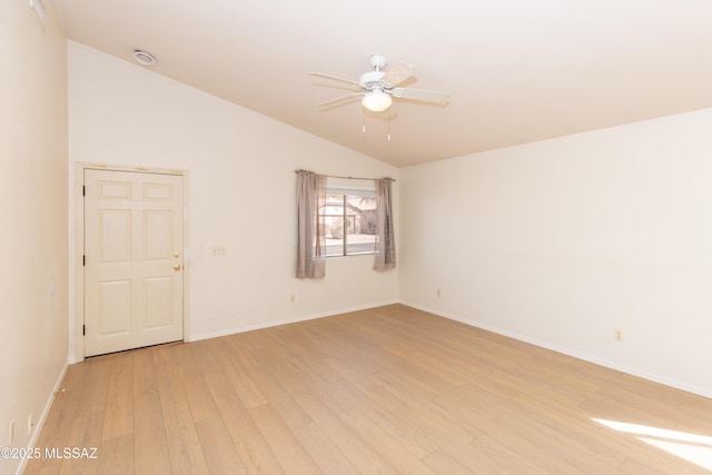 spare room featuring baseboards, vaulted ceiling, light wood finished floors, and ceiling fan