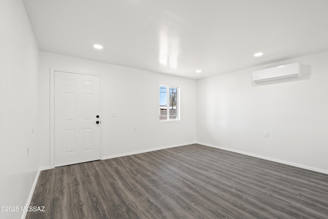 interior space featuring recessed lighting, dark wood-style flooring, a wall unit AC, and baseboards