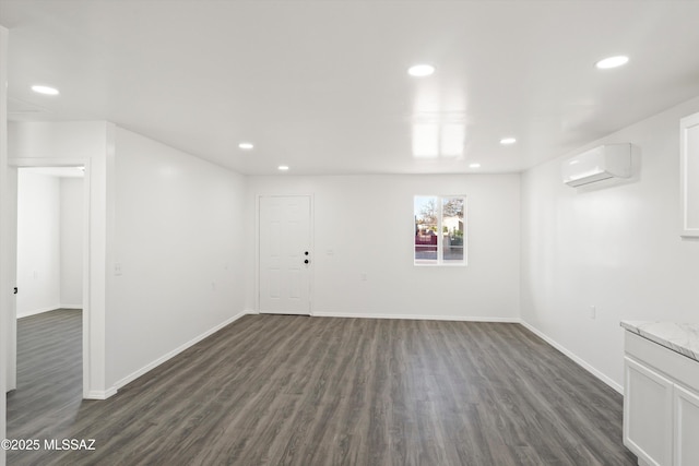 below grade area with dark wood-style floors, recessed lighting, and a wall mounted AC