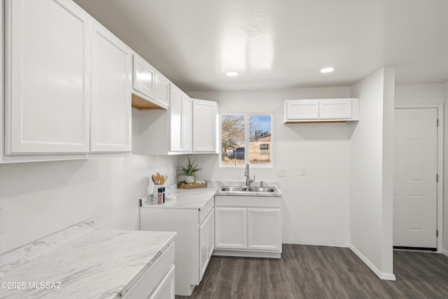 kitchen featuring recessed lighting, dark wood-style flooring, white cabinets, and a sink