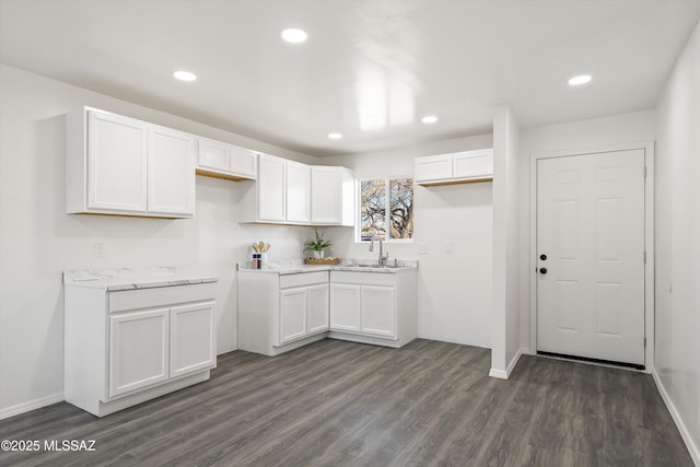 kitchen featuring dark wood finished floors, white cabinetry, a sink, and recessed lighting