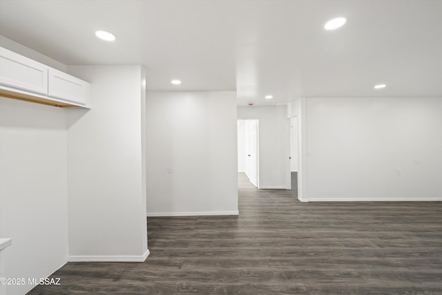 spare room with baseboards, dark wood-type flooring, and recessed lighting