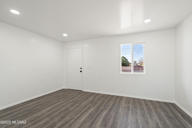 spare room featuring baseboards, dark wood-type flooring, and recessed lighting