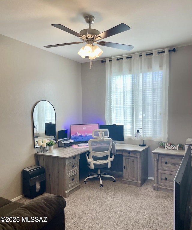 home office featuring light carpet and ceiling fan