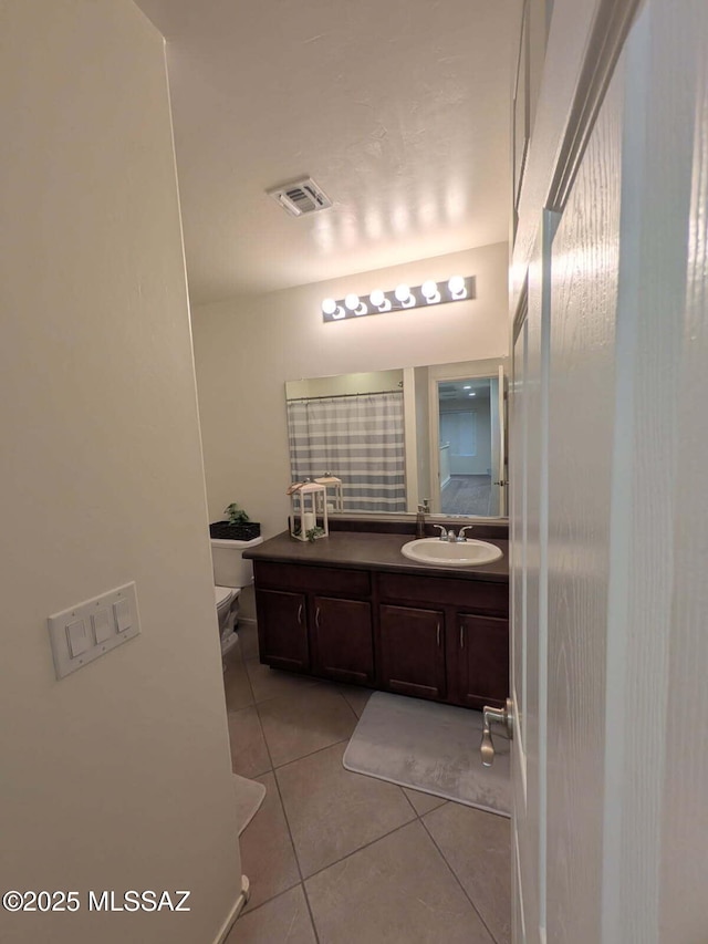 bathroom with visible vents, a shower with shower curtain, toilet, tile patterned floors, and vanity