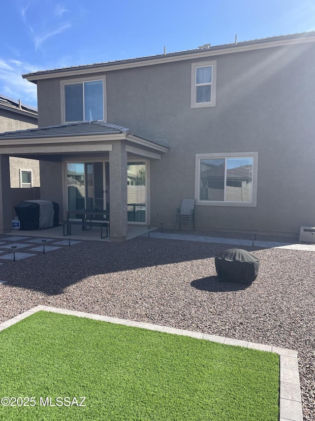 rear view of property featuring a patio area and stucco siding