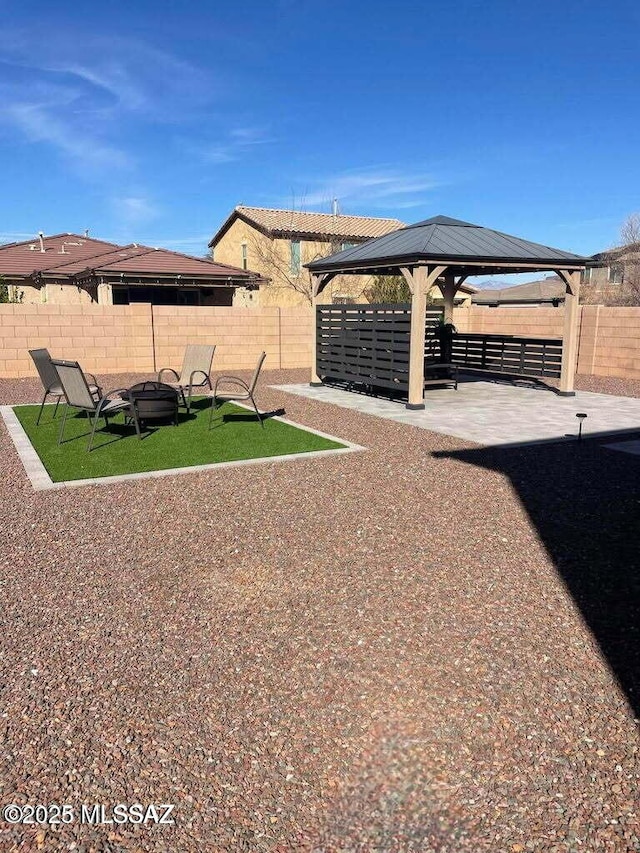 view of yard featuring a fenced backyard, a fire pit, a patio, and a gazebo