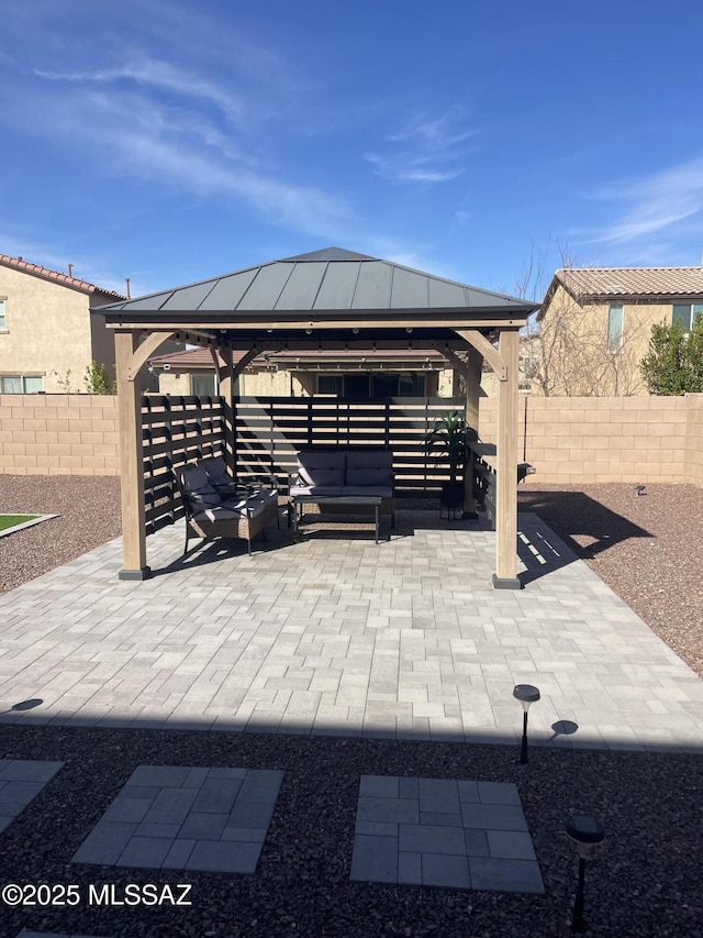 view of patio / terrace featuring fence, an outdoor living space, and a gazebo