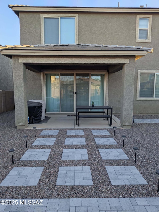 back of property featuring fence, a patio, and stucco siding