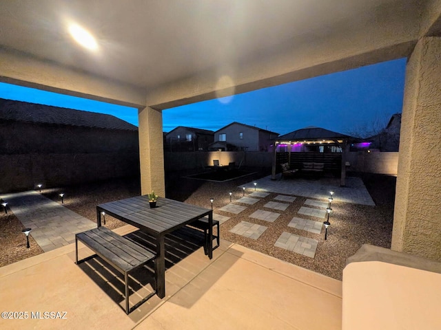 view of patio / terrace featuring a gazebo, outdoor dining area, and a fenced backyard