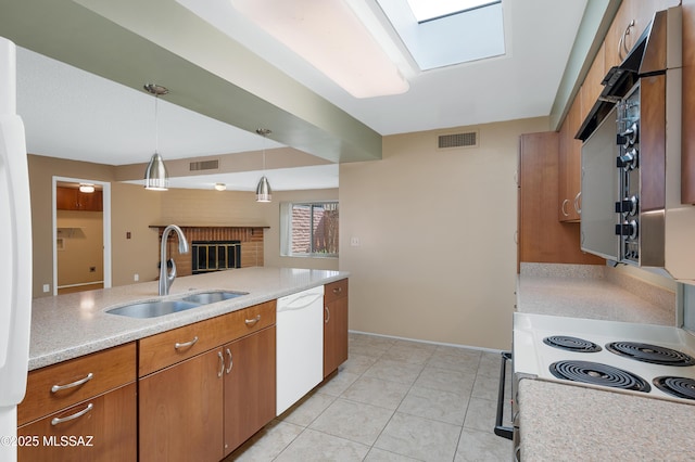 kitchen featuring dishwasher, electric range, visible vents, and a sink