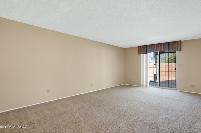 empty room featuring baseboards, a textured ceiling, and carpet flooring