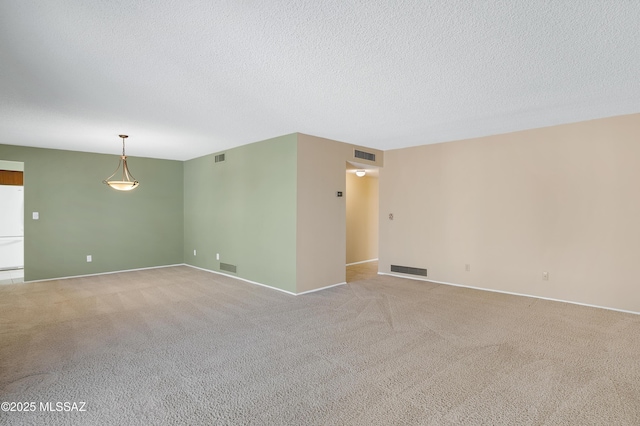 empty room with visible vents and light colored carpet