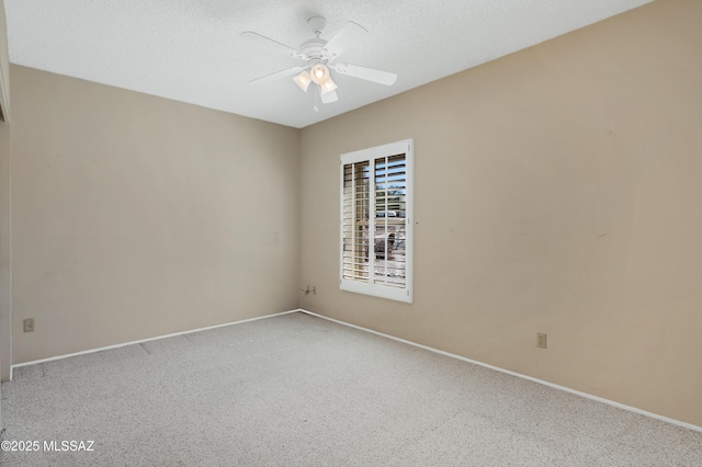 carpeted spare room with baseboards, a textured ceiling, and ceiling fan