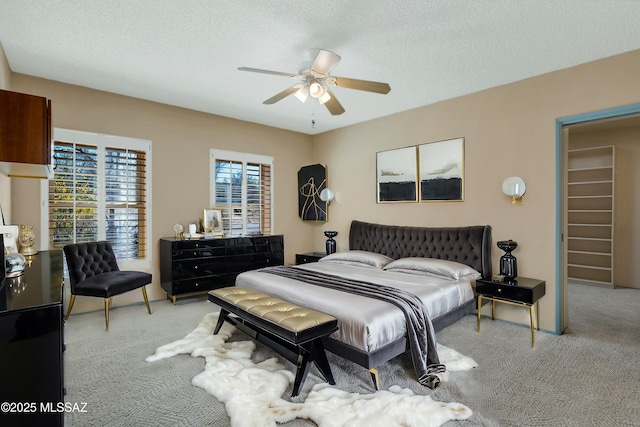 carpeted bedroom featuring a textured ceiling and a ceiling fan