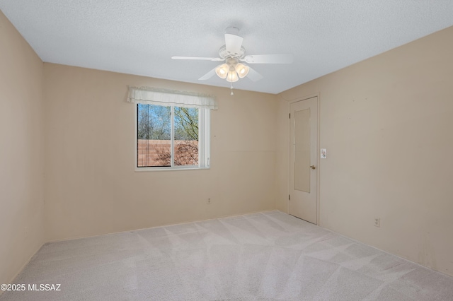 carpeted empty room featuring a textured ceiling and ceiling fan