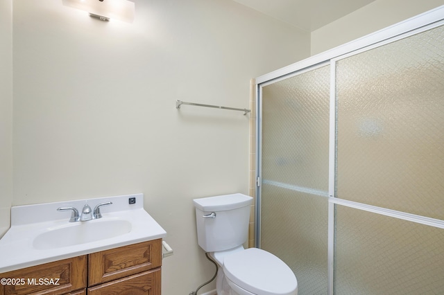 full bathroom featuring vanity, a shower stall, and toilet