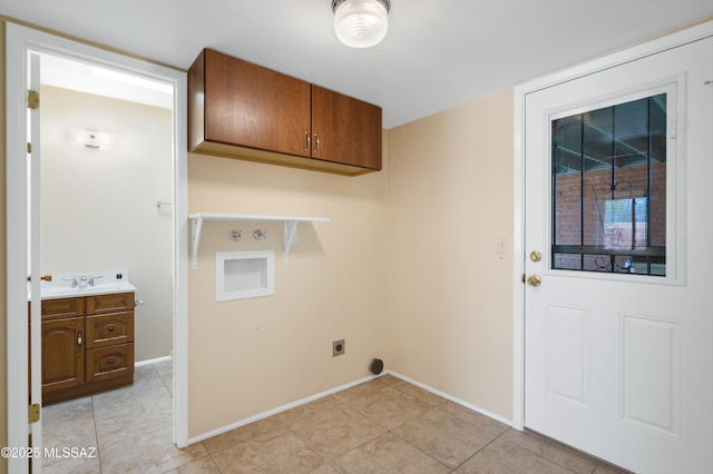 laundry area featuring electric dryer hookup, baseboards, cabinet space, and a sink