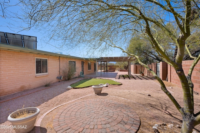 back of house featuring a patio, brick siding, a fenced backyard, and a pergola