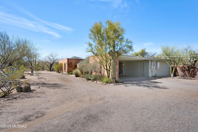 view of front of property with an attached carport, driveway, and stucco siding