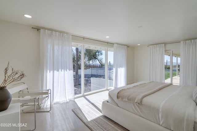 bedroom featuring access to exterior, recessed lighting, and wood finished floors