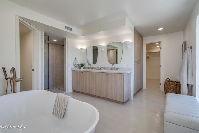 full bathroom featuring a freestanding tub, recessed lighting, concrete floors, a spacious closet, and a shower stall