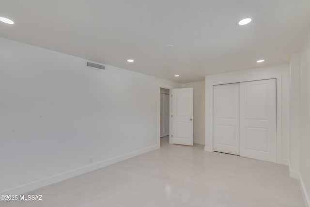 unfurnished bedroom featuring visible vents, baseboards, concrete floors, a closet, and recessed lighting