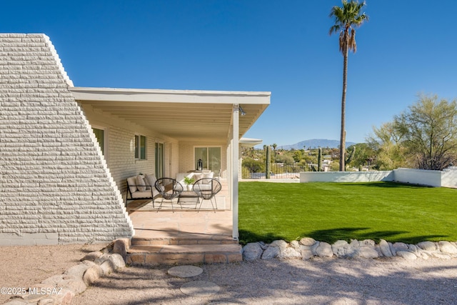 view of yard with fence, a mountain view, and a patio