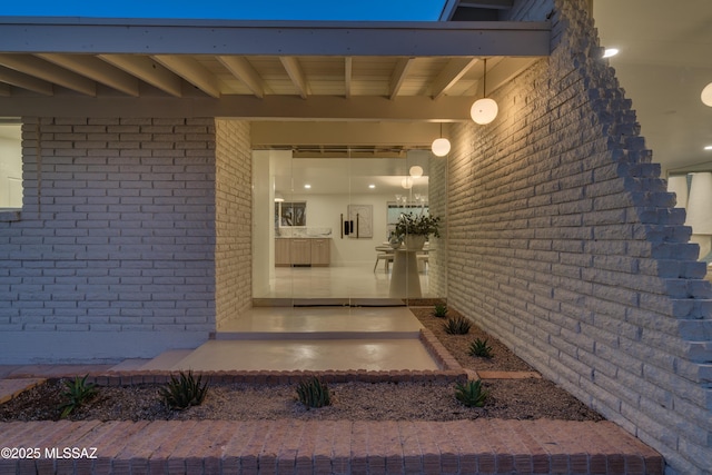 doorway to property featuring brick siding