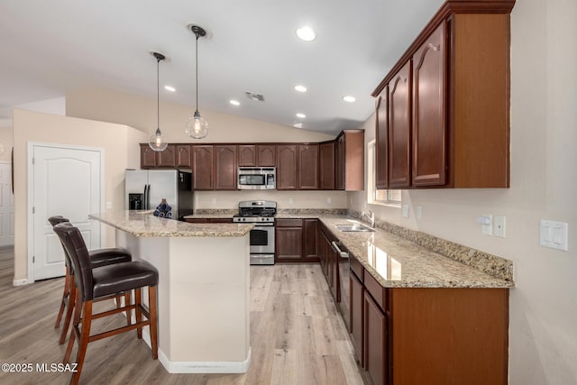 kitchen with a breakfast bar area, visible vents, light wood-style flooring, appliances with stainless steel finishes, and a sink