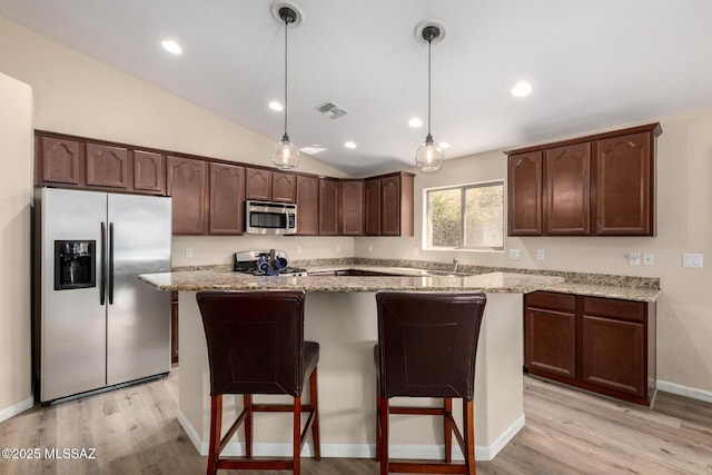 kitchen featuring light wood-style floors, visible vents, stainless steel appliances, and a center island