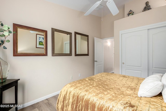 bedroom with a closet, ceiling fan, baseboards, and wood finished floors