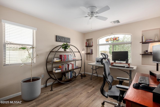 office area with ceiling fan, plenty of natural light, wood finished floors, and visible vents