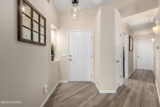 interior space with baseboards, visible vents, and wood finished floors