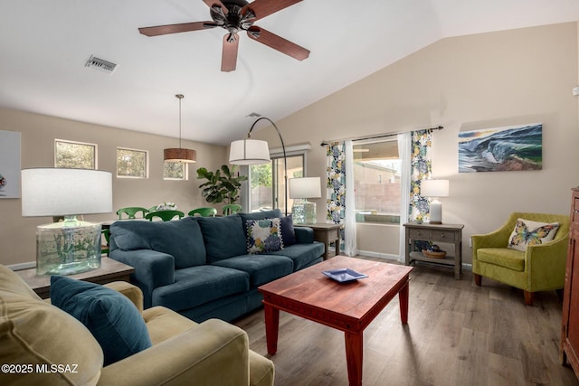 living area featuring high vaulted ceiling, a ceiling fan, visible vents, and wood finished floors