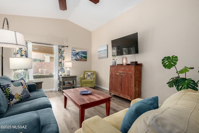 living room with lofted ceiling, light wood finished floors, ceiling fan, and baseboards