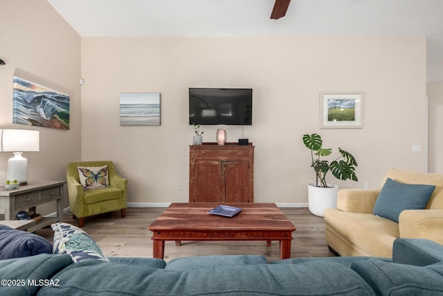 living area with baseboards and wood finished floors