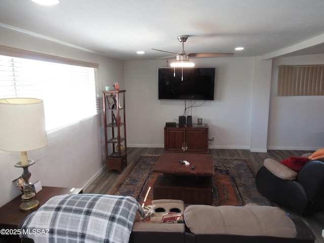 living area with ceiling fan, baseboards, and wood finished floors