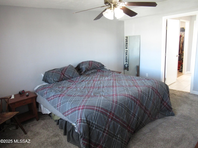 carpeted bedroom with a ceiling fan and tile patterned floors