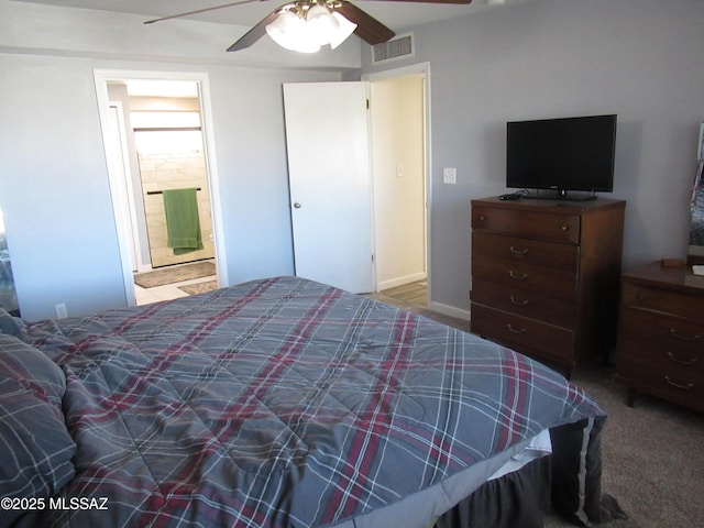 carpeted bedroom with visible vents, ceiling fan, and ensuite bath