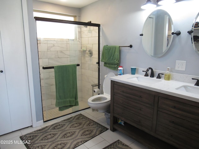 bathroom with double vanity, a stall shower, a sink, and tile patterned floors