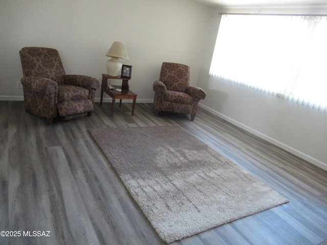 living area with baseboards and wood finished floors