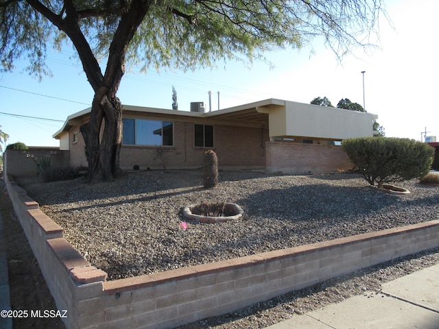 view of front facade with central AC unit and brick siding