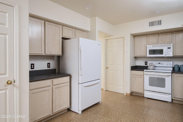 kitchen with white appliances, dark countertops, light brown cabinets, and visible vents