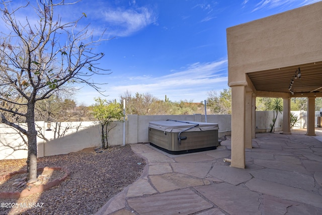 view of patio / terrace featuring a hot tub and a fenced backyard