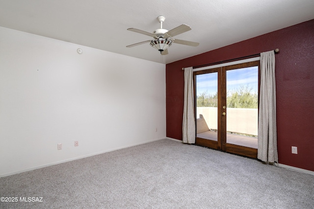 carpeted spare room featuring french doors, a ceiling fan, and baseboards