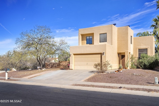 adobe home with a garage, concrete driveway, and stucco siding