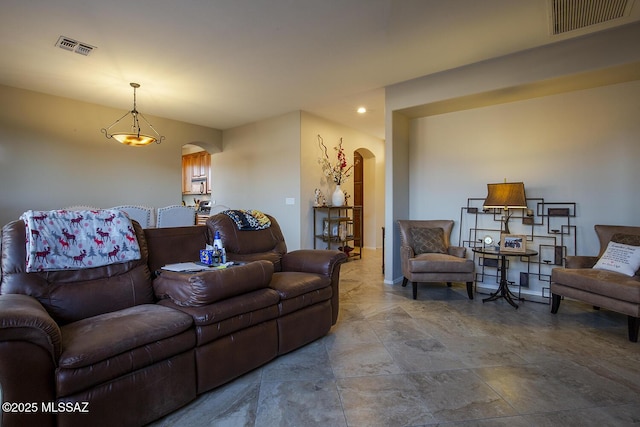 living room with arched walkways and visible vents