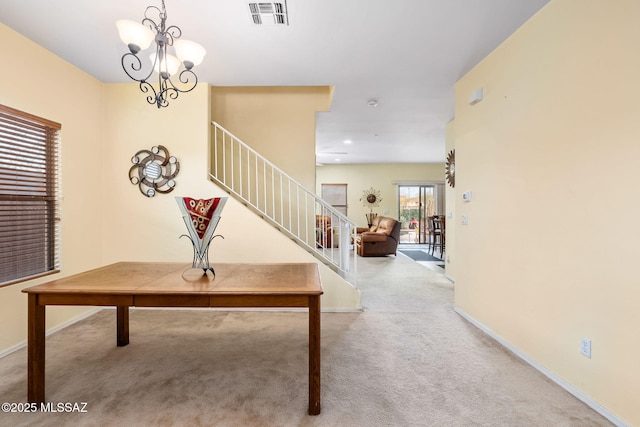 carpeted entrance foyer with a chandelier, visible vents, baseboards, and stairs